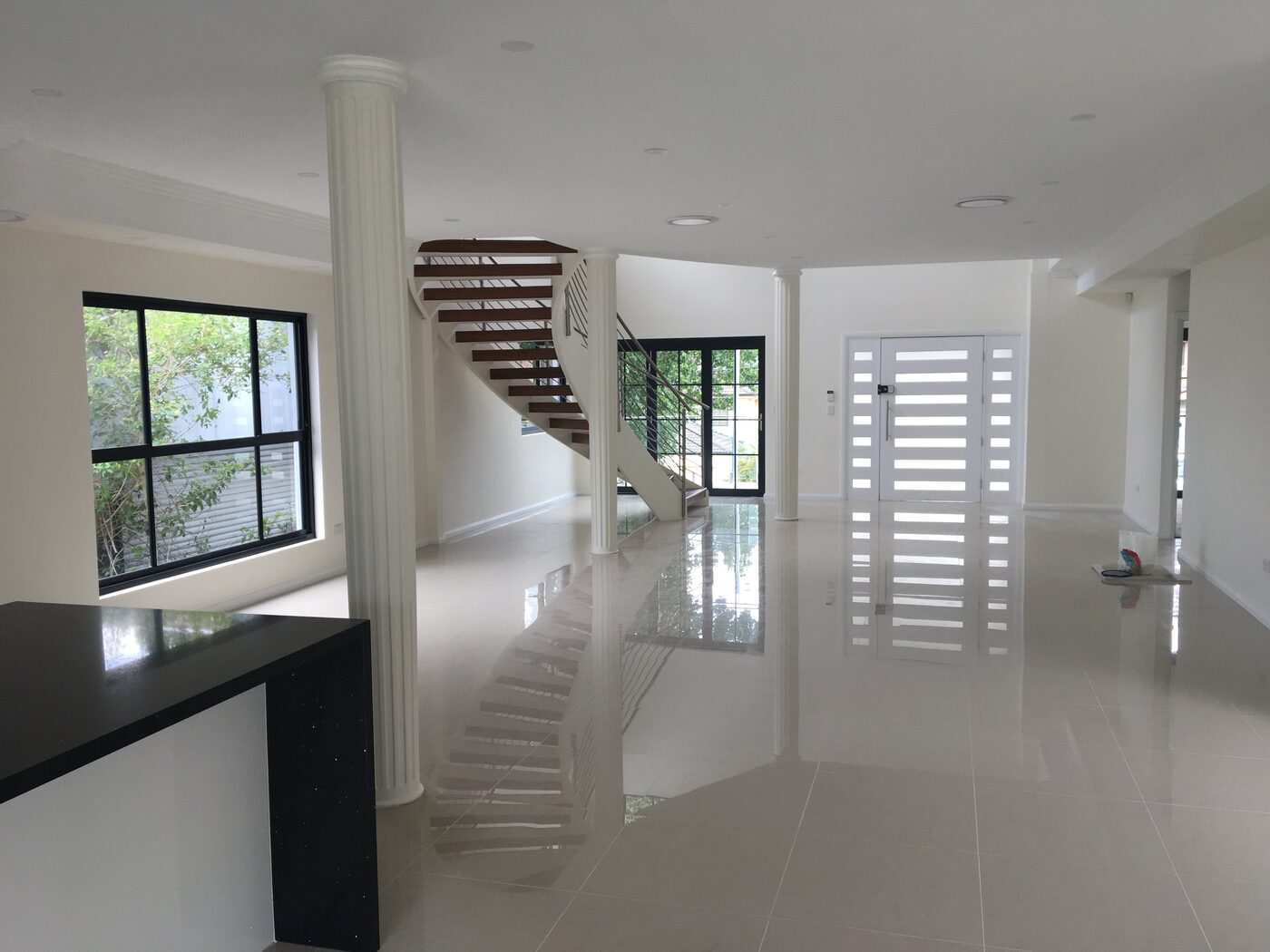 Ground-floor open-plan living with the timber staircase and full-height windows