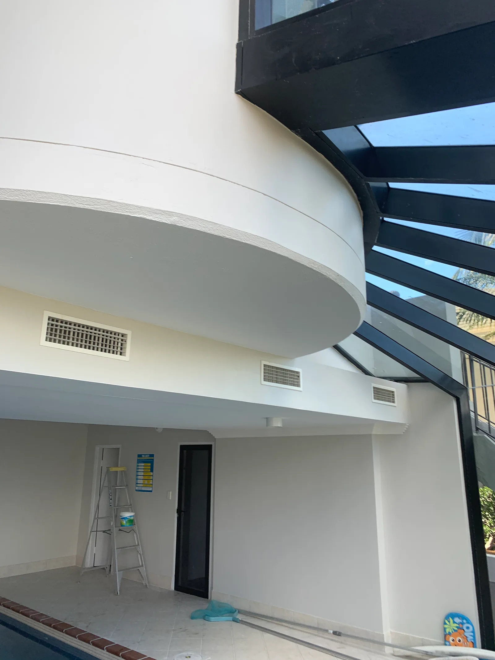 The curved balcony soffit and glazed roof detail, photographed during finishing.