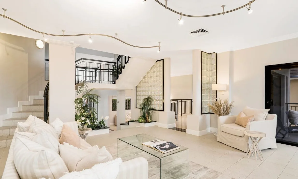 The open living space, with a timber-look staircase and a glass-block feature wall.