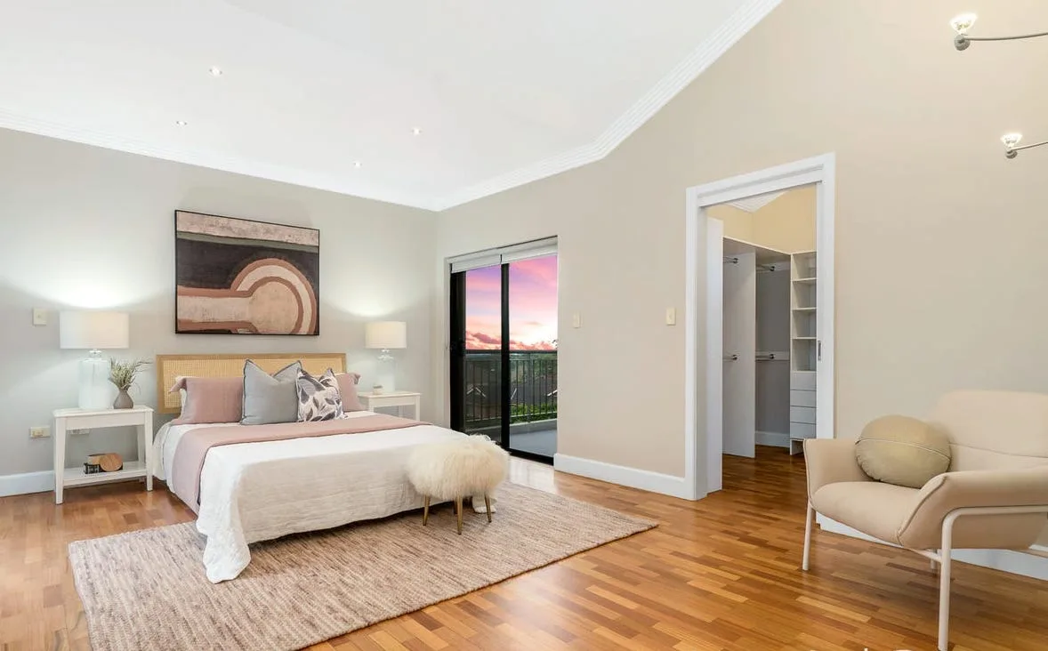 The main bedroom, with sliding doors to a balcony and an open walk-in wardrobe.