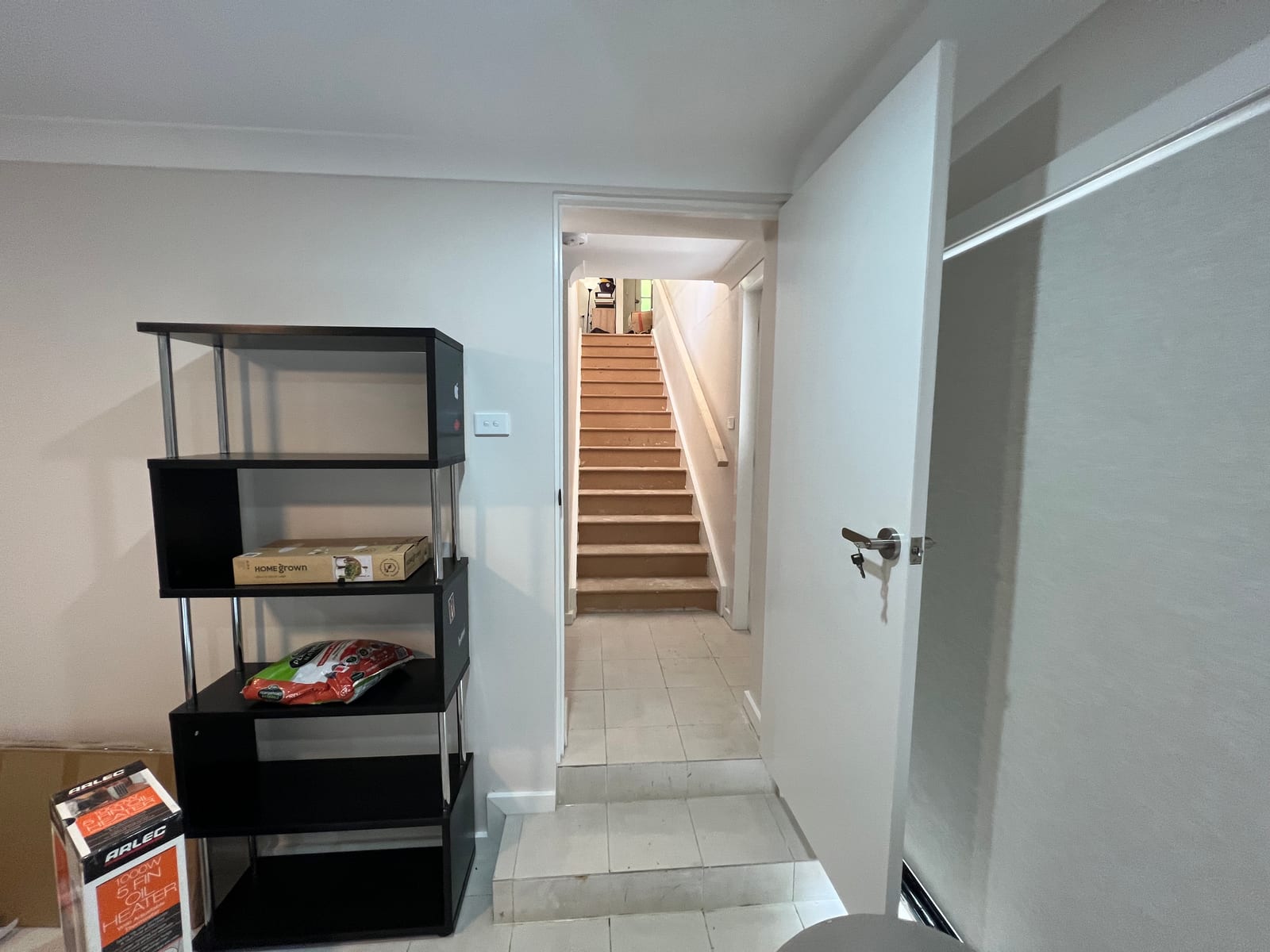 The new internal staircase down to the lower-ground level, with tiled flooring at the base