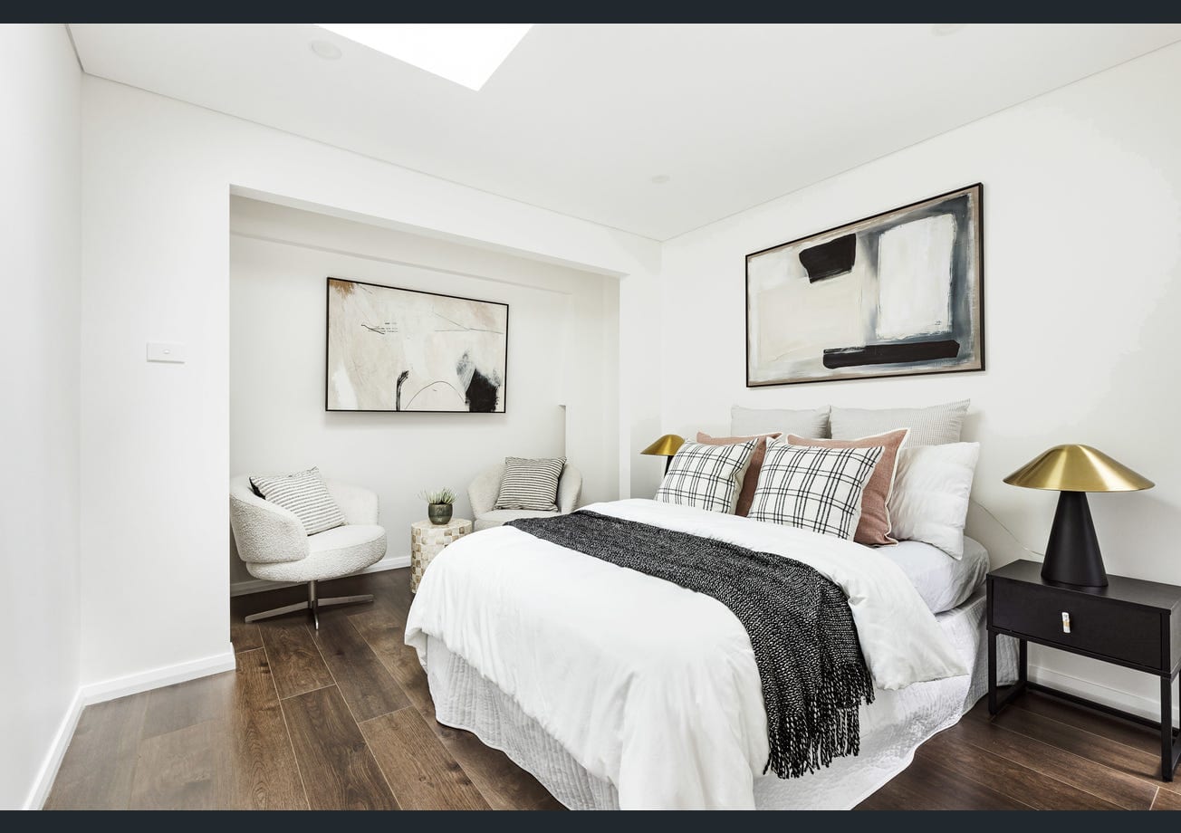 A second finished bedroom with a skylight and a two-armchair sitting nook