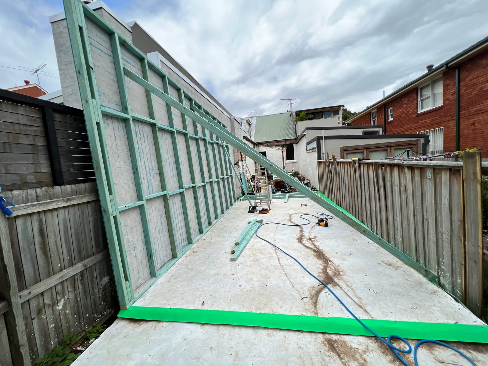 During construction — a new timber-and-steel wall frame erected in the rear yard