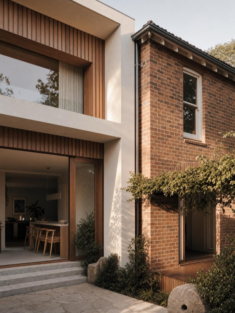 Home extension where a new render-and-timber addition meets the original brick home — illustrative concept