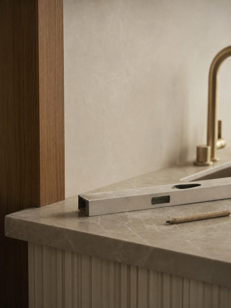 Spirit level and pencil on a freshly installed stone benchtop on site — illustrative concept